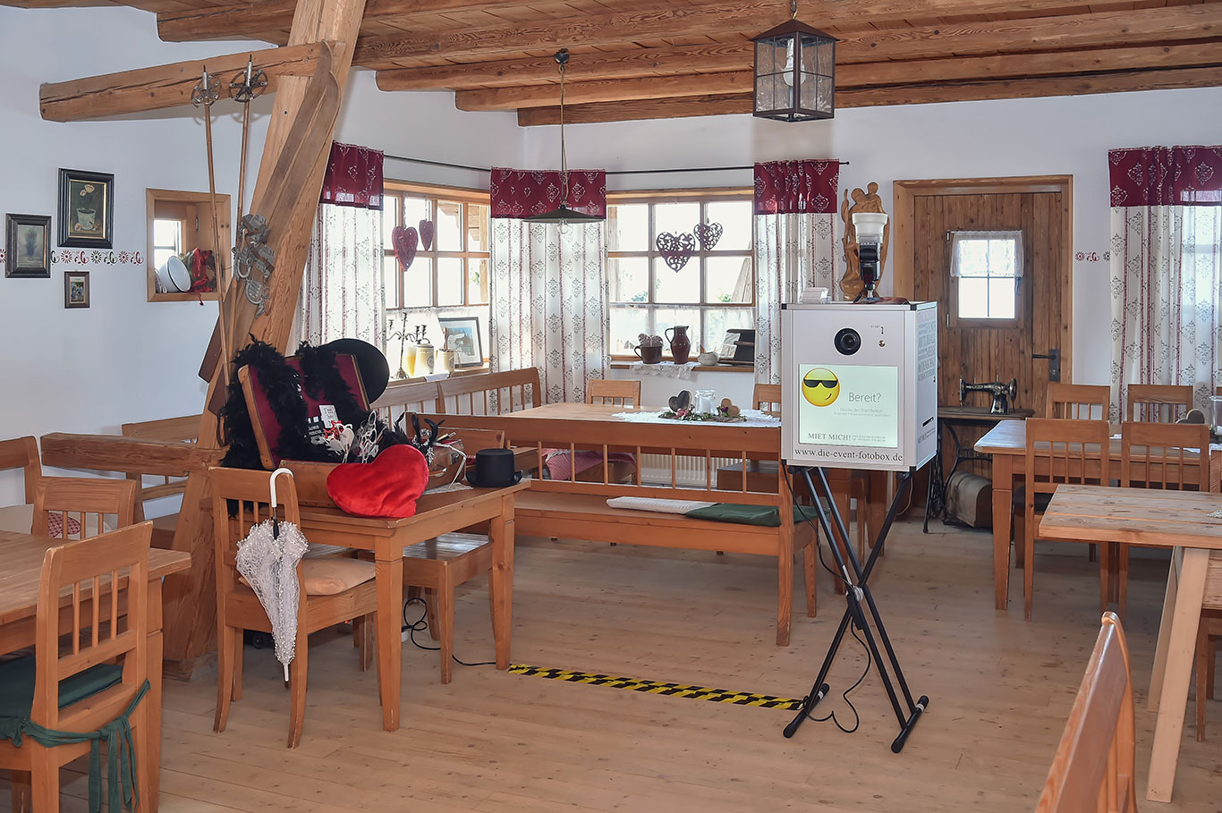 Fotobox in einer rustikalen Location mit rotem Vorhang